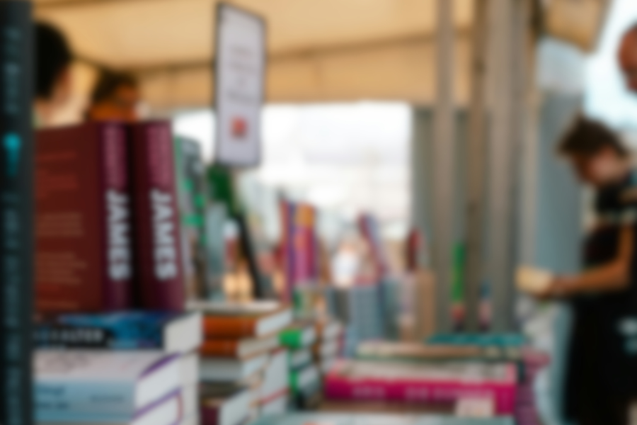 Photo by <a
        href='https://unsplash.com/@kovah'>Kevin
        Woblick</a> on <a
        href='https://unsplash.com/photos/a-number-of-books-on-a-table-with-people-in-the-background-NgPdyZFV29w?utm_source=unsplash&utm_medium=referral&utm_content=creditCopyText'>Unsplash</a>